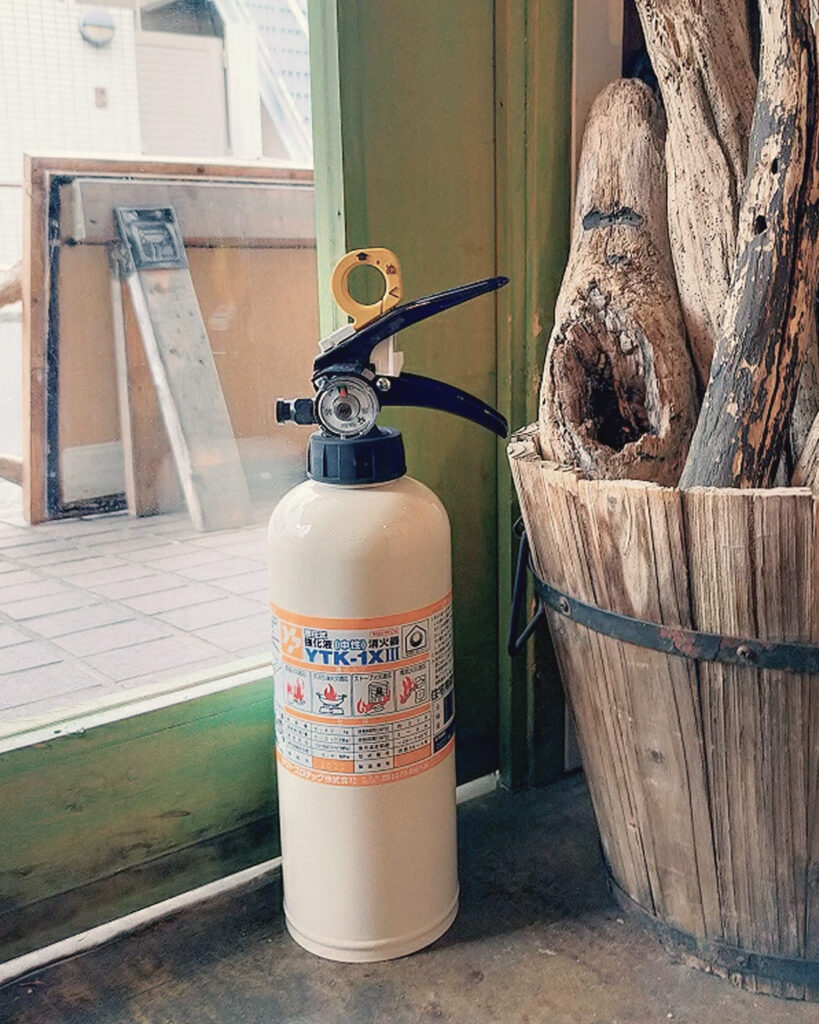 白い消火器と観葉植物の鉢植え